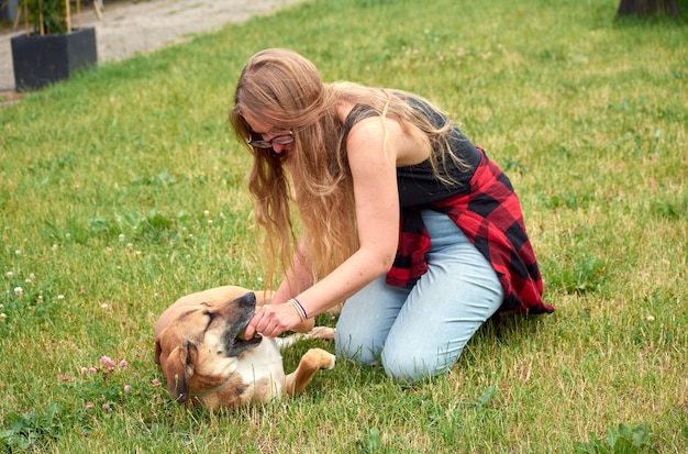 Uma foto de close de uma menina branca caucasiana no parque com seu cachorro