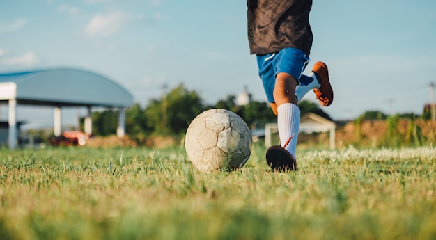 Uma foto de esporte de ação de crianças jogando futebol futebol americano para se exercitar no campo de grama verde