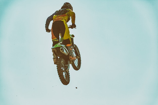 Foto uma foto de um motociclista fazendo uma acrobacia e pula no ar