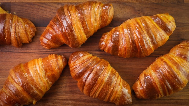 Uma foto em close de croissants em uma mesa de madeira