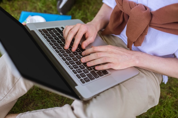 Uma foto em close-up de um homem digitando em um laptop