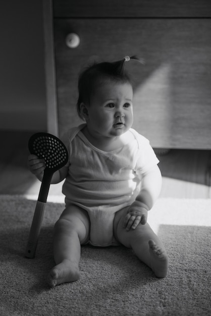 Foto uma foto em preto e branco de uma menina de um mês está sentada no tapete