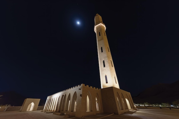 Uma foto noturna de uma mesquita islâmica com uma lua