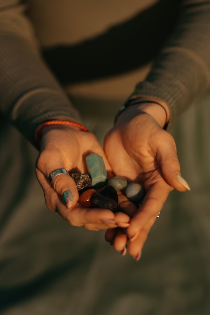 Uma foto próxima de um monte de pedras na mão de uma mulher para terapia mágica