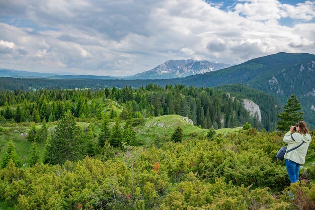 Uma fotógrafa faz um instantâneo de uma magnífica paisagem montanhosa