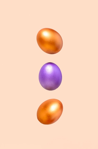 Foto uma fotografia minimalista de três ovos voadores contra um fundo bege pastel com espaço de cópia vertical formatxa