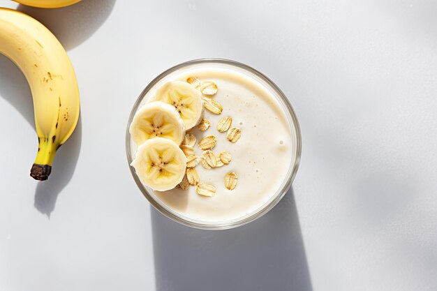 Foto uma fotografia mostrando um copo de smoothie de aveia e banana ou milk-shake de baunilha colocado em um mar vibrante