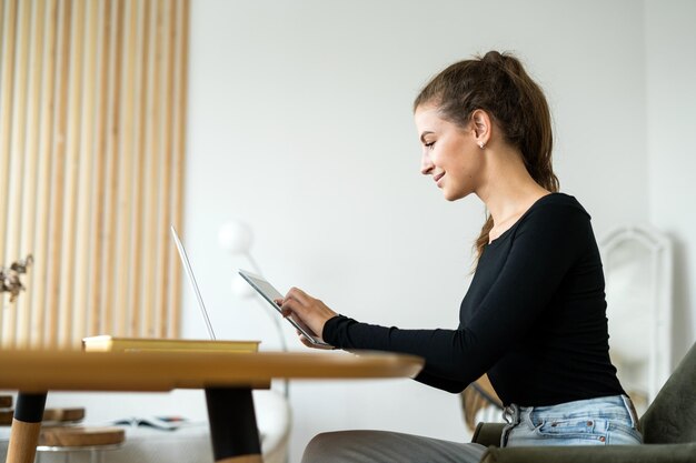 Uma freelancer feminina trabalha em um escritório usa um aluguel de espaço de coworking para laptop