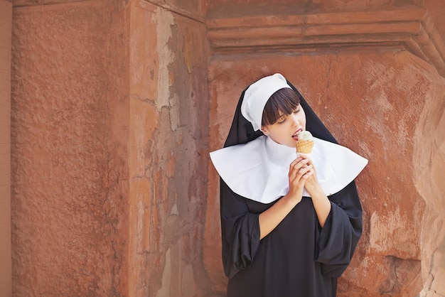 Foto uma freira comendo uma casquinha de sorvete