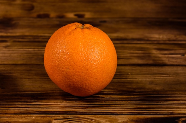 Uma fruta laranja na mesa de madeira rústica
