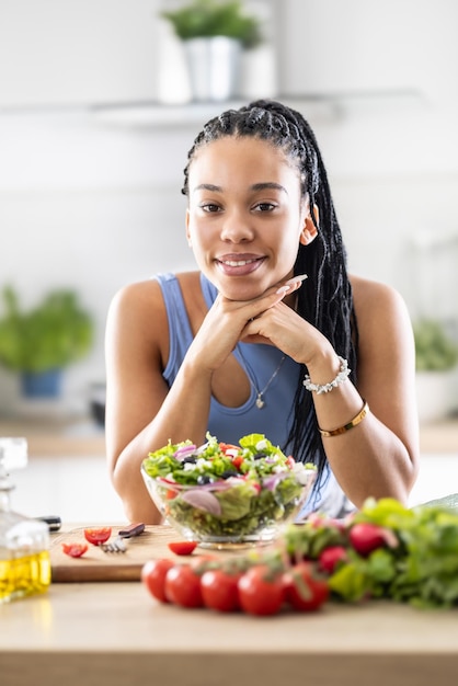 Foto uma garota afro-americana bonita preparou uma salada mista saudável de legumes frescos