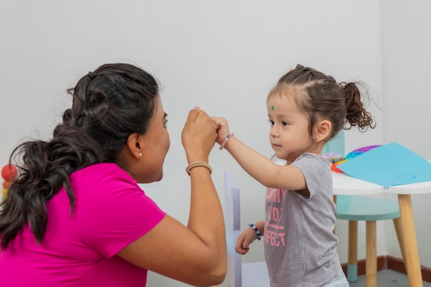 Uma garota bate o punho com o médico pediatra após sua consulta na clínica