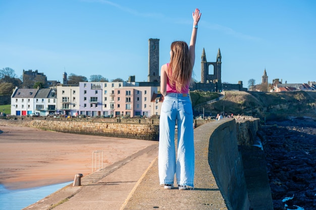 Uma garota caminha ao longo do passeio marítimo na cidade de St Andrews, no Reino Unido