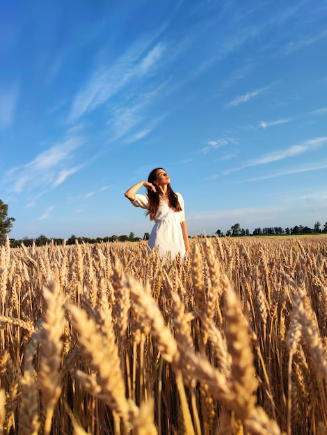 Uma garota caminha graciosamente entre cevada e trigo na ucrânia. aprecia a beleza da natureza ucraniana.