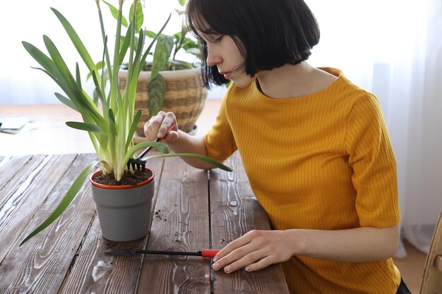 Uma garota coloca uma flor em uma panela