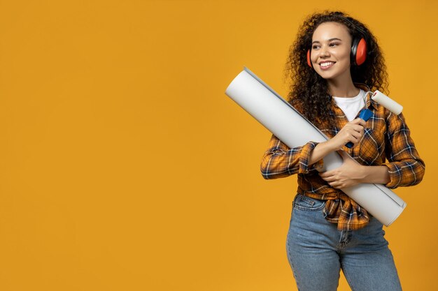 Uma garota com fones de ouvido de construção e com um rolo e papel nas mãos