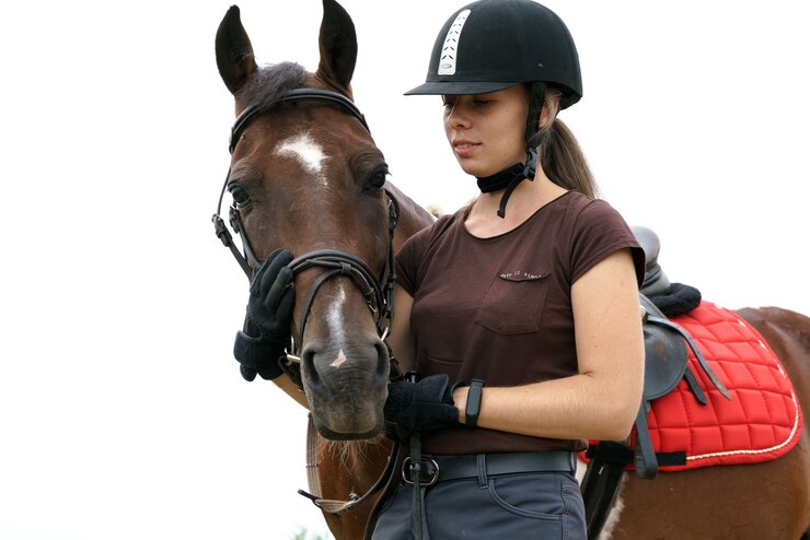 Foto uma garota com um capacete e equipamento de equitação se comunica com seu cavalo skewbald