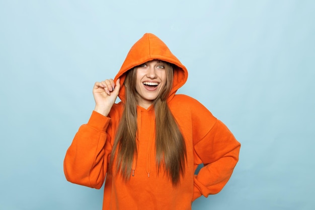 uma garota com um capuz laranja está fazendo um sinal de paz
