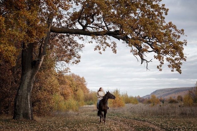 Foto uma garota com um cavalo na natureza, um passeio no outono com um animal