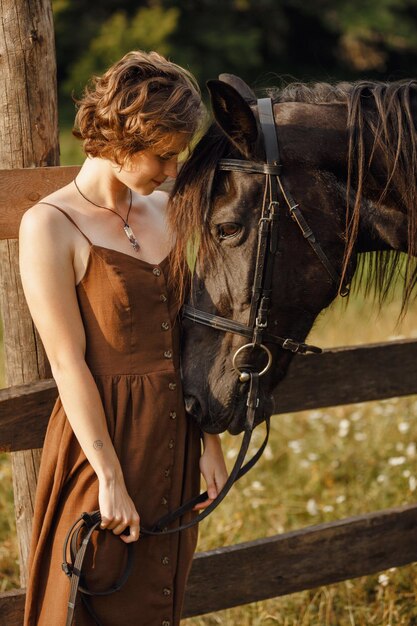 Foto uma garota com um cavalo um vestido marrom um homem na natureza com um animal