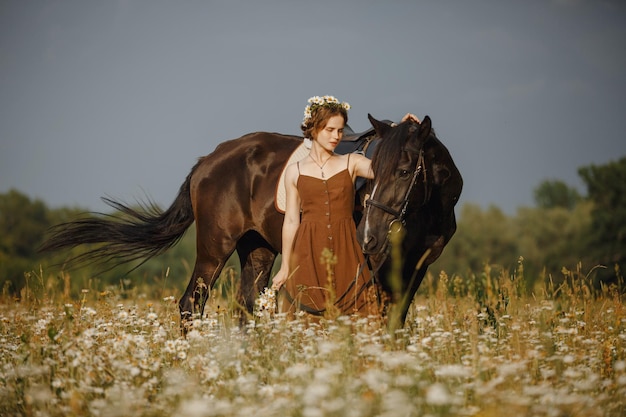 Uma garota com um cavalo um vestido marrom um homem na natureza com um animal