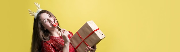 Uma garota com um vestido vermelho com presentes em um fundo amarelo