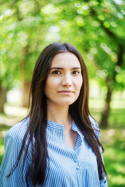 Uma garota de aparência asiática em um parque da cidade. Retrato de verão