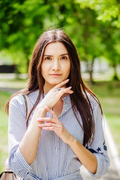 Uma garota de aparência asiática em um parque da cidade. Retrato de verão