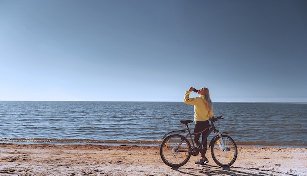 Uma garota de bicicleta à beira-mar