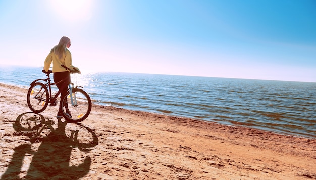 Uma garota de bicicleta à beira-mar