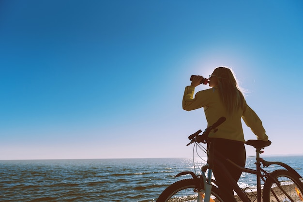 Uma garota de bicicleta à beira-mar