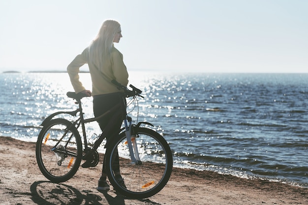 Uma garota de bicicleta à beira-mar