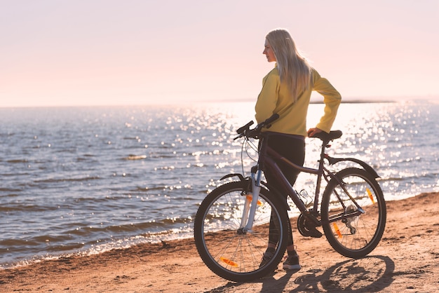 Uma garota de bicicleta à beira-mar