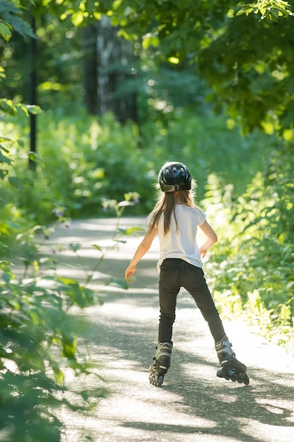 Uma garota de capacete patinando no parque em seus rolos