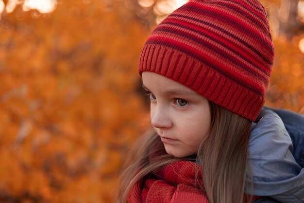 Uma garota de chapéu vermelho olha para a câmera.