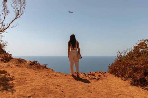Uma garota de costas e um drone voador no céu