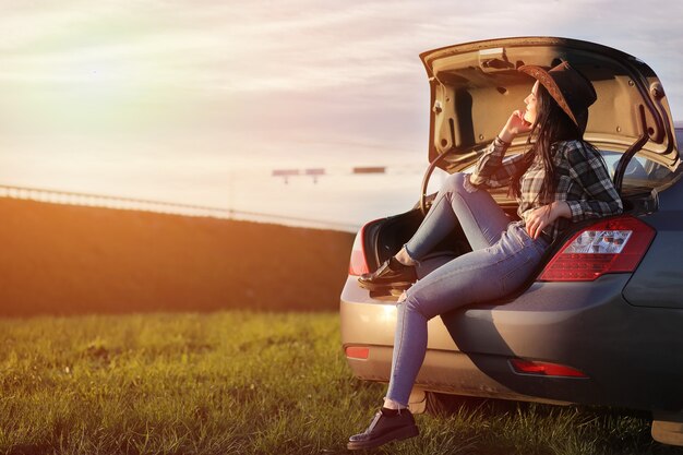 Foto uma garota de jeans e chapéu viaja o verão no interior