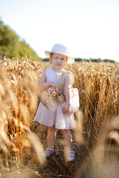 Uma garota de vestido branco em um campo de trigo Horário de verão Dia da proteção das crianças