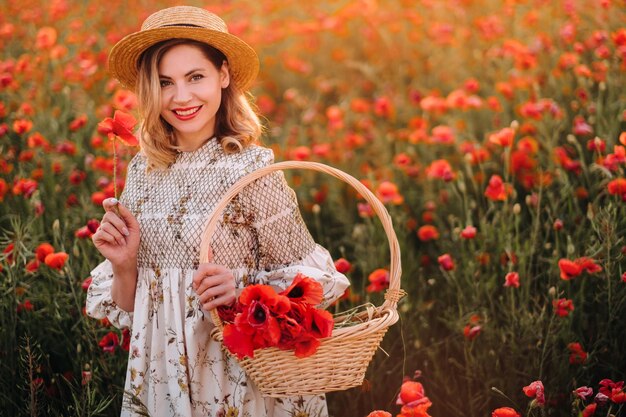 Uma garota de vestido com chapéu e cesta em um campo com papoulas