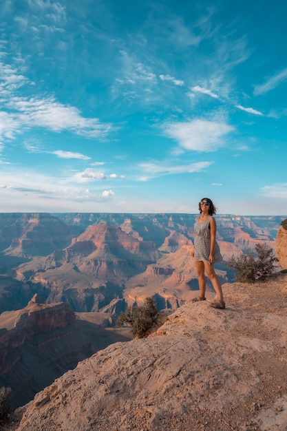Uma garota de vestido preto e branco ao pôr do sol no Ponto Mojave do Grand Canyon