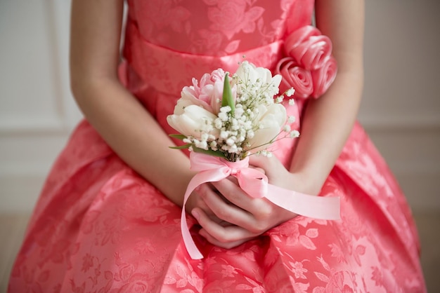 Uma garota de vestido rosa segurando um buquê de flores nas mãos Humor de primavera Dia da Mulher