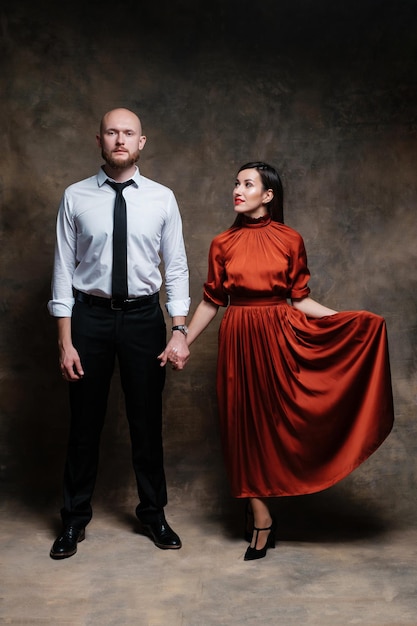 Uma garota de vestido vermelho e homem barbudo careca lindo casal posando