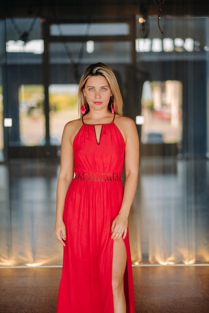 Uma garota de vestido vermelho se move em uma dança meditando dentro de casa Dança dinâmica