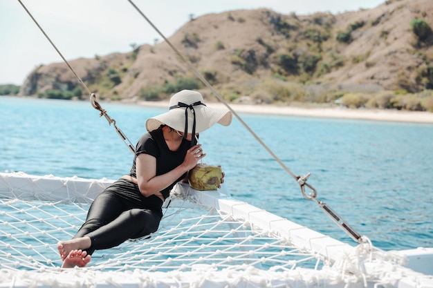 Uma garota desfrutando de coco durante as férias de verão no mar