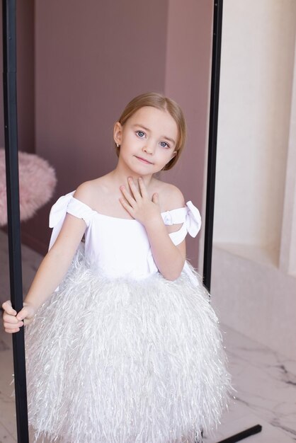 Uma garota doce e muito bonita em um vestido chique sorri no feriado do Dia das Crianças