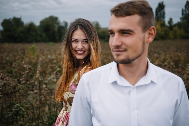 Uma garota e um cara estão caminhando na natureza. Romance