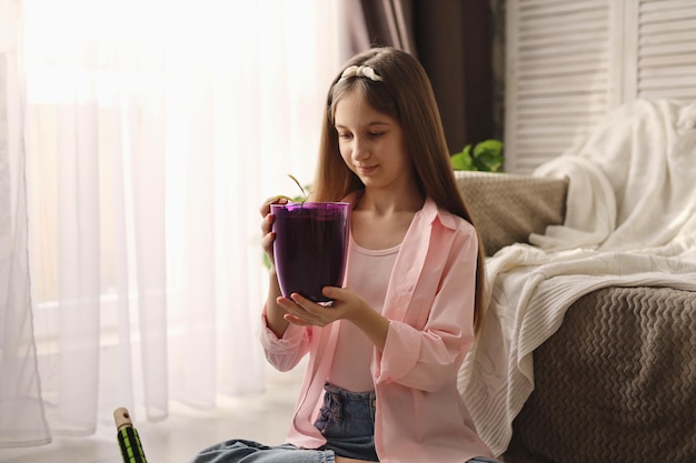 uma garota em casa tem uma semente de manga em um vaso de flores passo a passo instruções etapa seis