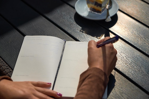 Foto uma garota em um café escreve em um caderno