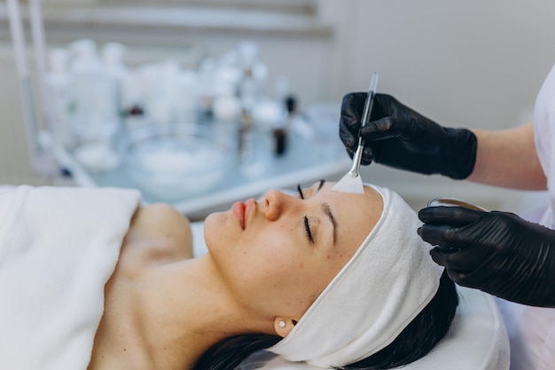Uma garota em um cosmetologista faz procedimentos cosméticos limpeza da pele