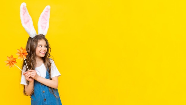 Uma garota em um vestido com orelhas de coelho em um fundo amarelo